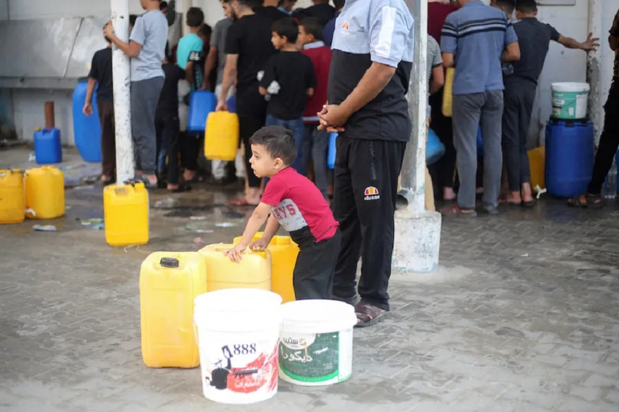 Los palestinos recogen agua en medio del actual conflicto palestino-israelí en Khan Younis, en el sur de la Franja de Gaza.