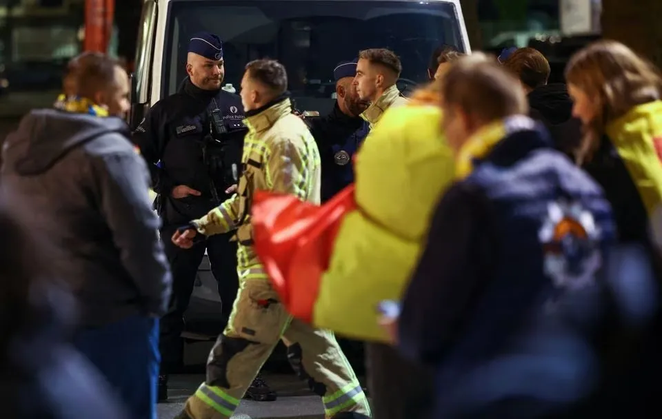 Agentes de policía aseguran el área fuera del estadio Rey Balduino después de un tiroteo en Bruselas, Bélgica.