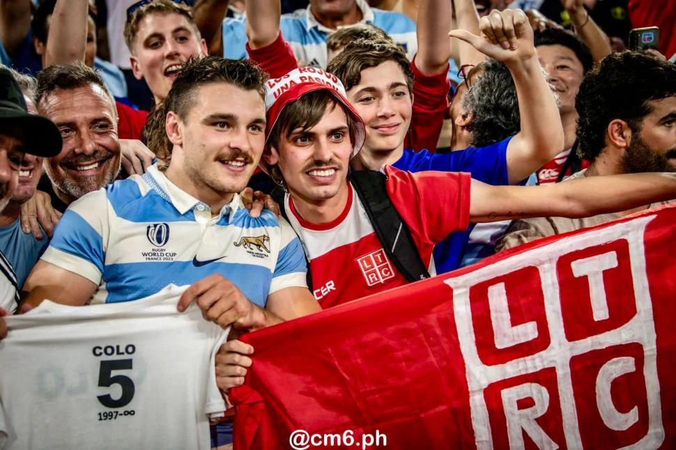 “ROJOS” DE ALMA. Mateo Carreras junto a Nicolás Sabeh, sosteniendo la remera que recuerda al “Colo” Danieli, luego del partido contra Gales.
