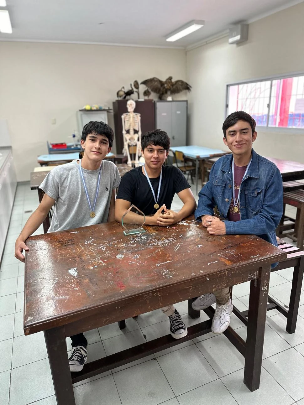 ORGULLOSOS DE SU LOGRO. Mateo Giordano, Lautaro Lo-Re y Ian Arrieta posan en el laboratorio del colegio.