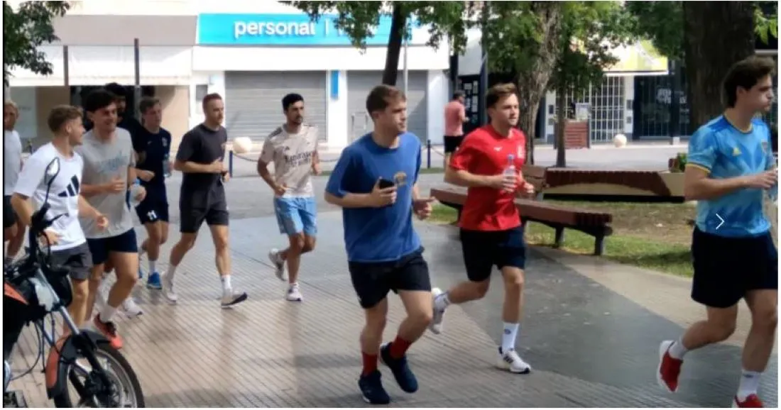TROTE. Gran Bretaña usó la plaza principal santiagueña para practicar. A la derecha, uno de los jugadores porta una remera xeneize de entrenamiento.