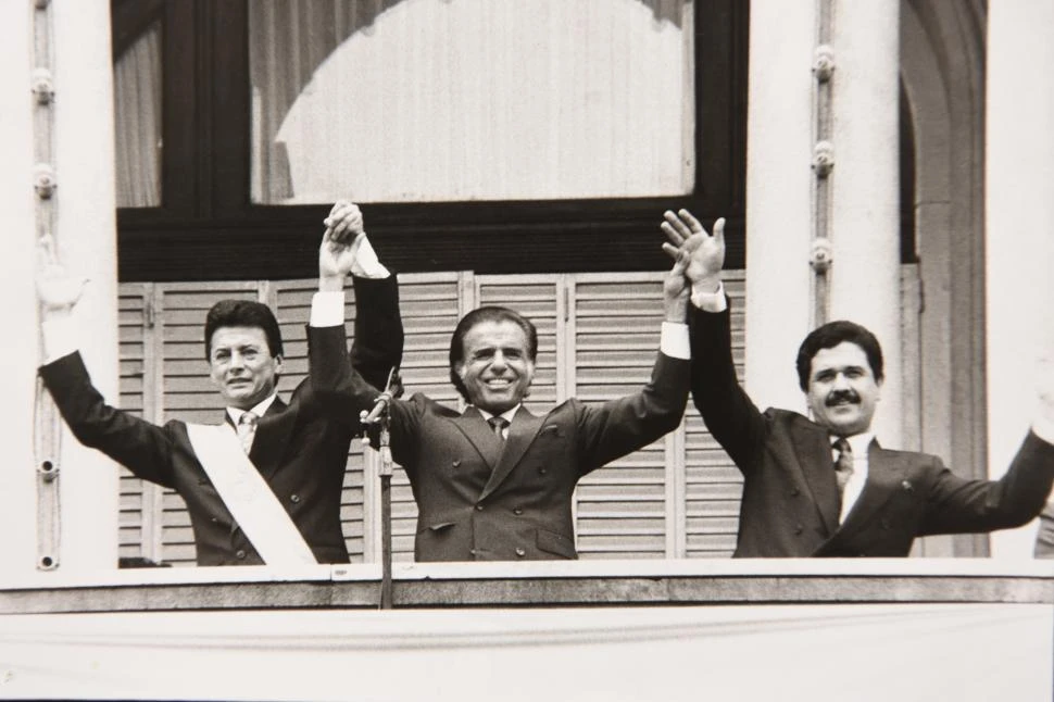 1991. En Tucumán, el presidente Carlos Menem levanta las manos de sus dos delfines: a su derecha está el hasta entonces interventor federal Julio César Aráoz y a su izquierda, el gobernador Ramón Bautista Ortega, “Palito”.