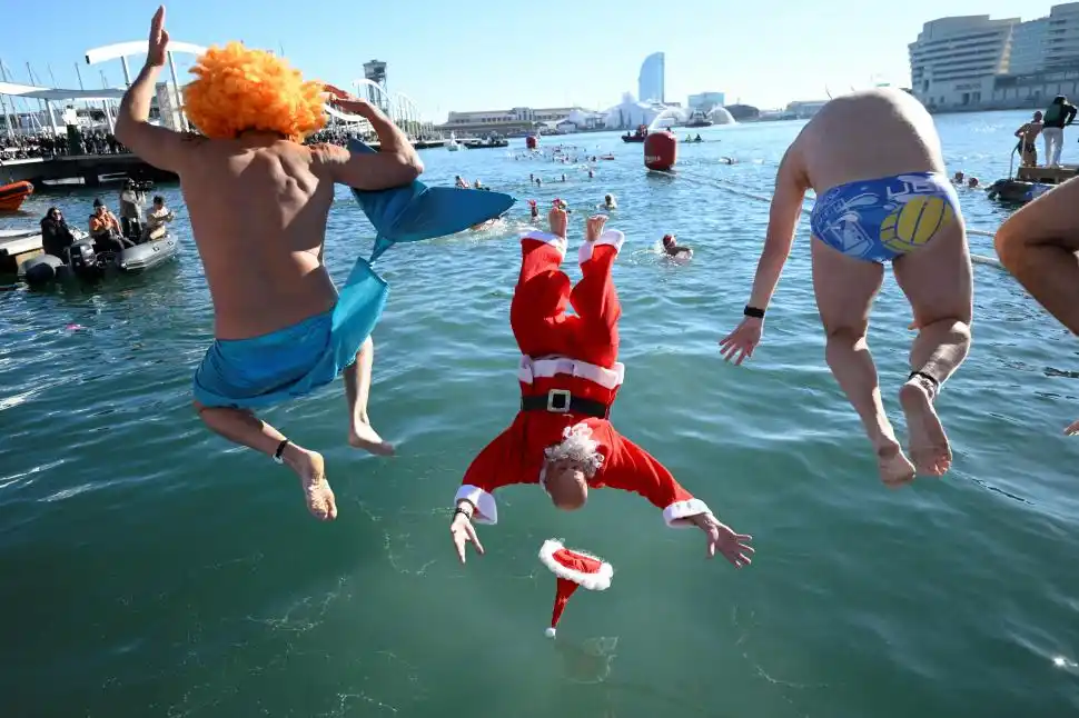 EN ALEMANIA. Delante de una pantalla gigante en la que se suceden formas y colores luminosos,  un artista vestido de San Claus saluda y envía buenos deseos desde su tradicional trineo, en un mercado de Berlín.