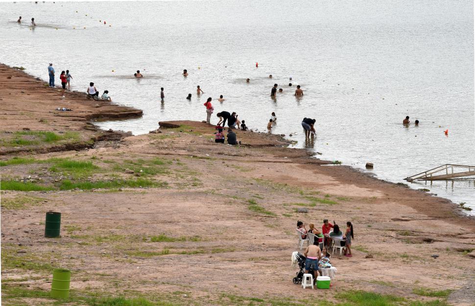 ATRACCIÓN. Aunque el calor de ayer no resultó agobiante, igualmente varias personas entraron a bañarse en las aguas frescas de El Cadillal.