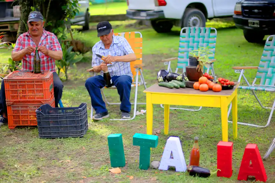Los hombres ajustan con alambre el corcho de una botella para que no se abra durante la cocción