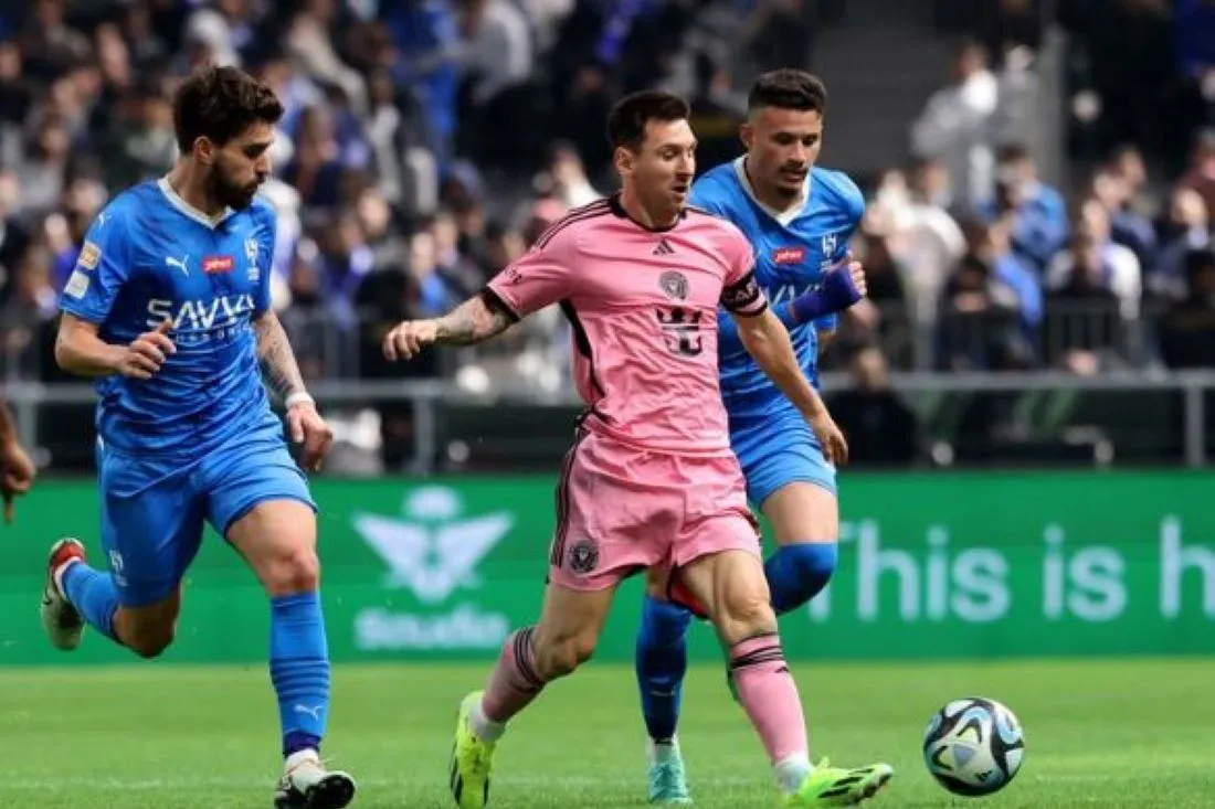 MARCADO. Abdullah Al-Hamdan y Ruben Neves presionan a Messi que se lleva el balón.