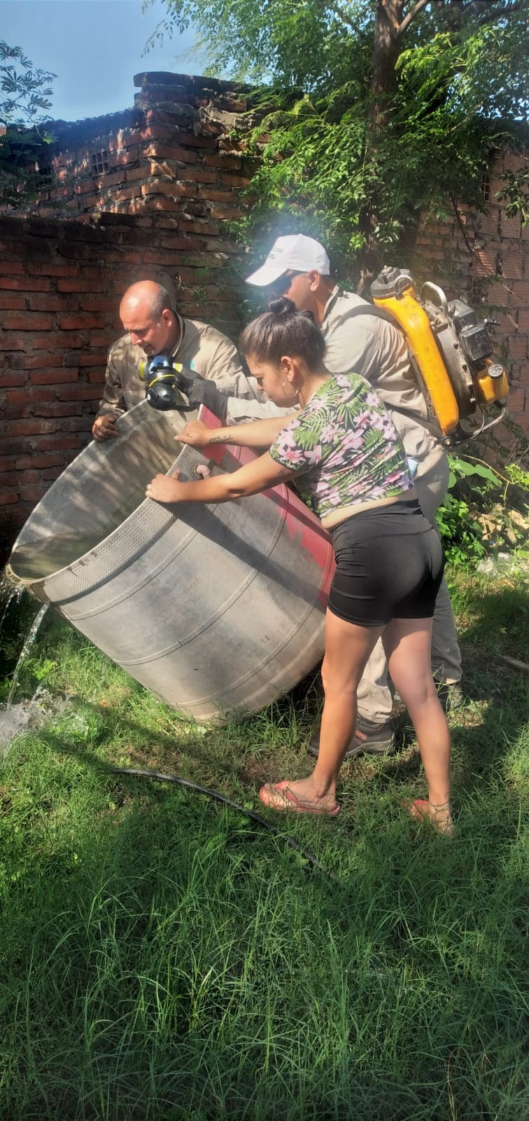 OPERATIVO. Agentes ayudan a vaciar un tanque con larvas de Aedes. salud ambiental del siprosa
