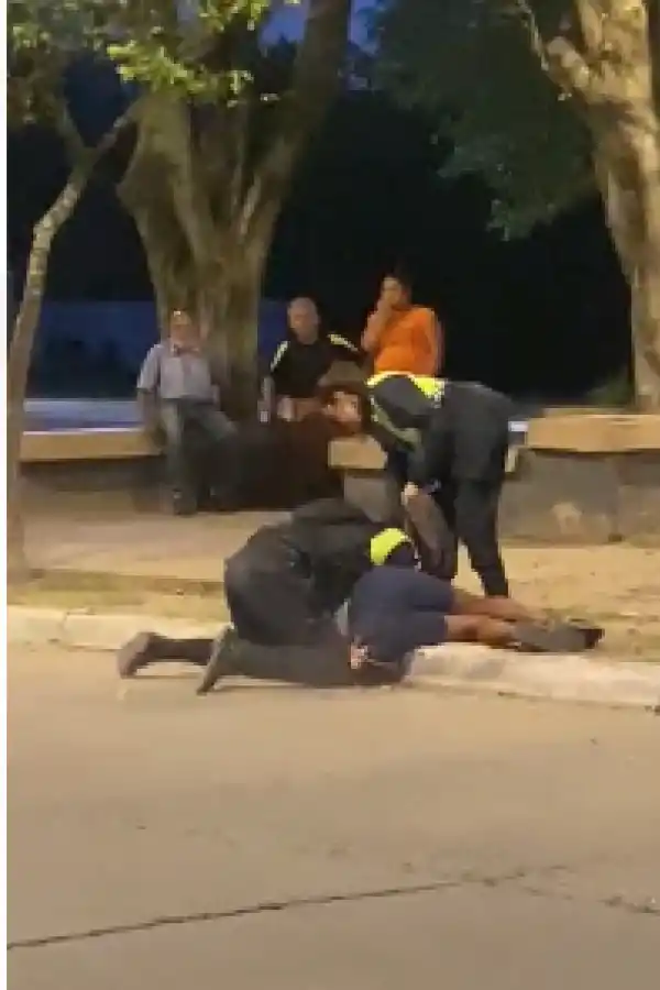 ESFUERZO. Dos policías reducen al acusado ante la mirada de vecinos.