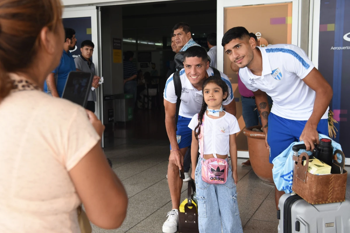 BUEN HUMOR. Nicolás Castro y Adrián Sánchez accedieron al pedido de una pequeña fanática en la salida del aeropuerto tucumano. FOTOS DE JOSÉ NUNO