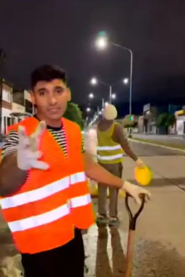 LA TAREA. Los jóvenes, con chalecos reflectantes, arreglan el bache.