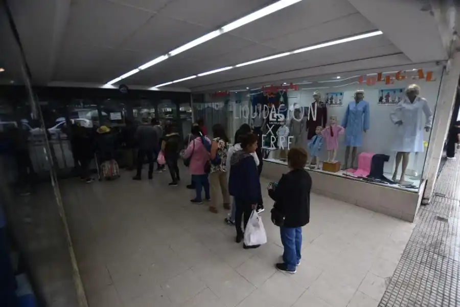 EN LA CALLE. Clientes hacen largas colas para realizar su última compra.