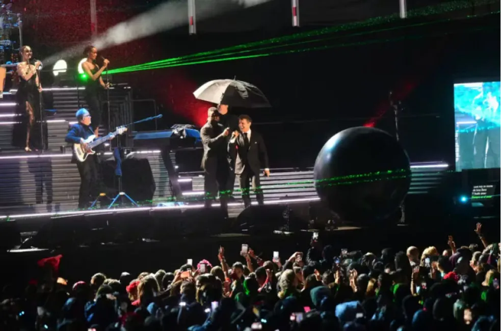El artista apareció en el escenario acompañado de un asistente con paraguas