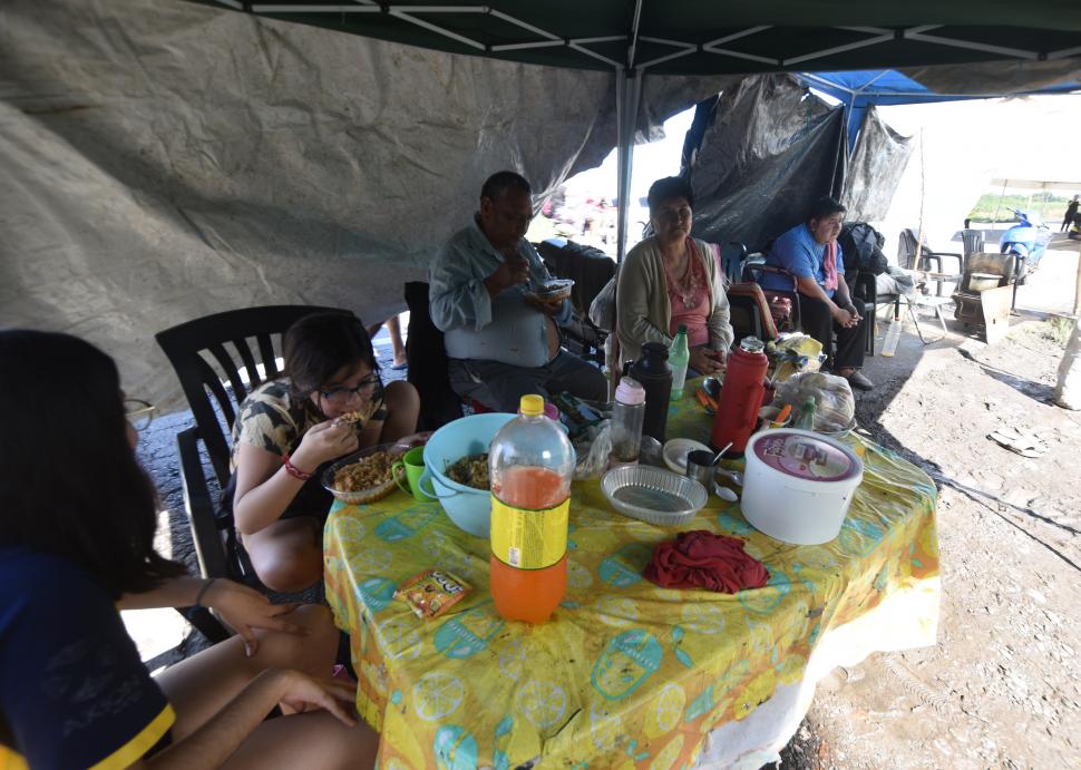 PLATO CALIENTE. Una de las familias evacuadas almuerza bajo un gazebo.