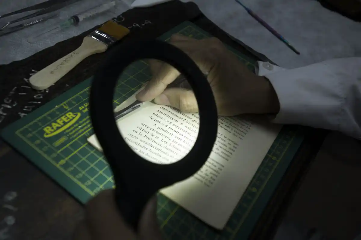 BUSCANDO DETALLES. La intervención requiere revisar centímetro a centímetro cada página, en procura de analizar el estado del libro.