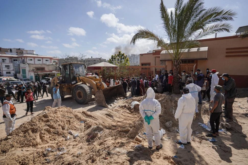 EXHUMACIÓN. Trabajadores de salud monitorean la excavación en el patio del hospital Nasser. 