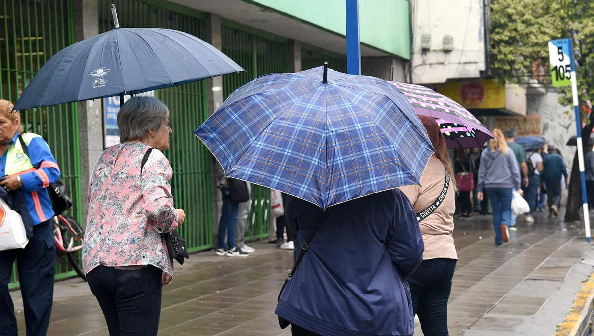 CON EL PARAGUAS. Las tucumanas se alistaron para la lluvia este miércoles en la capital.