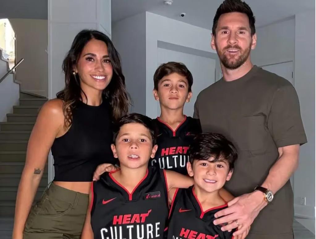 Messi junto a sus hijos luciendo el regalo de los Miami Heat. 