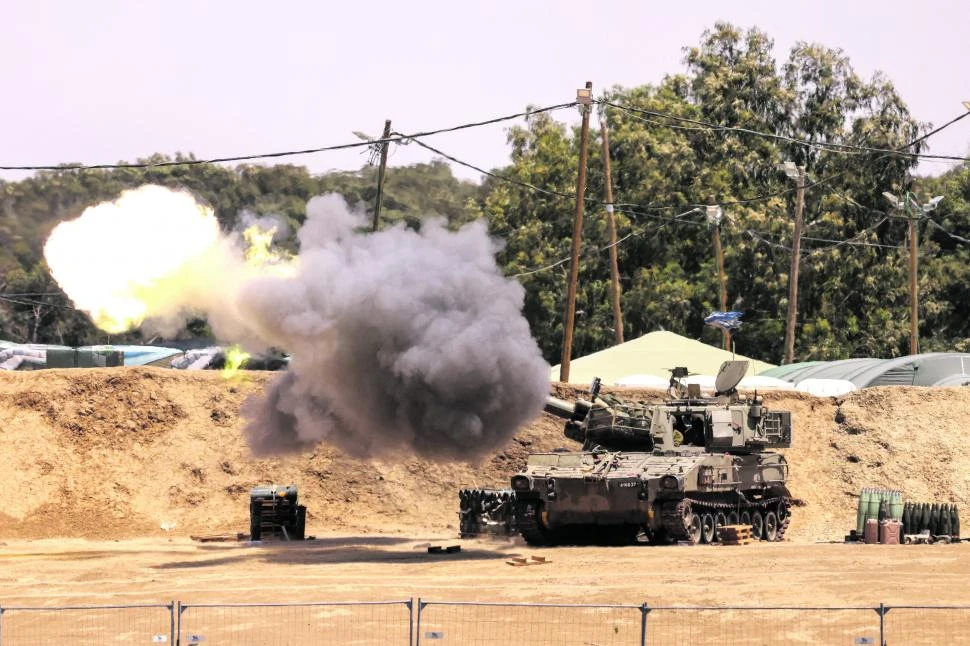 BAJO FUEGO. Una unidad de artillería móvil dispara un proyectil desde una posición fronteriza en el sur de Israel hacia la Franja de Gaza.
