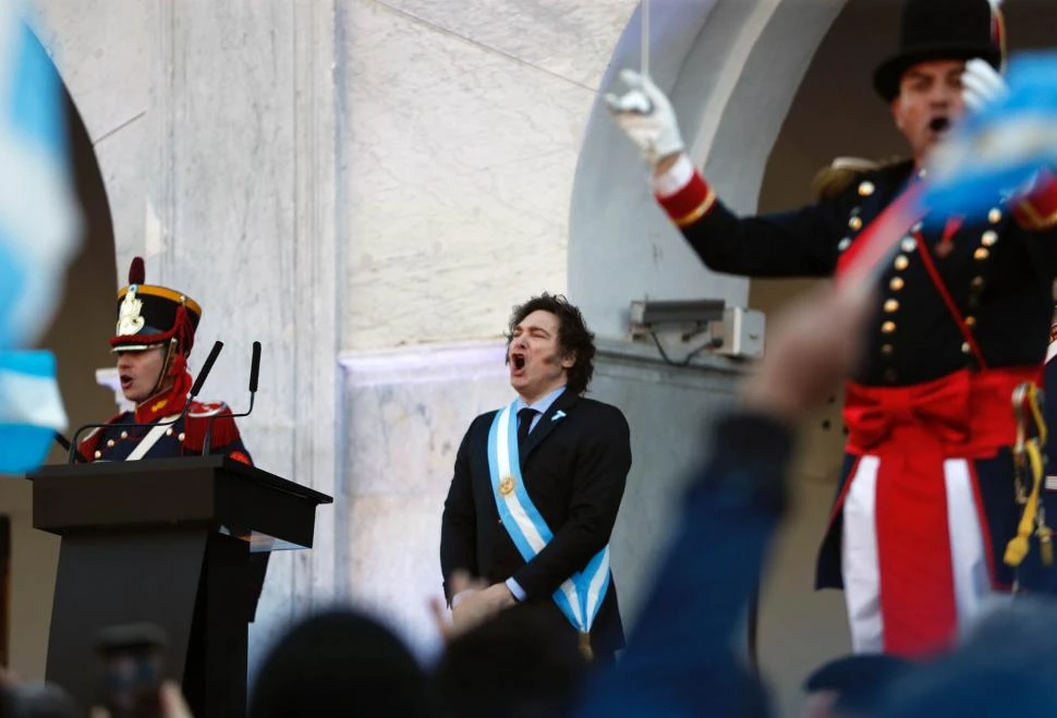 EN EL CABILDO CORDOBÉS. Javier Milei luce los atributos presidenciales, mientras entona las estrofas del Himno Nacional. na