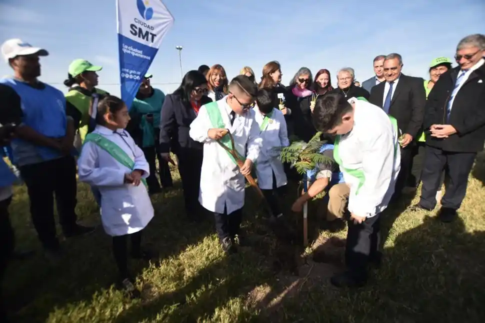 REFORESTACIÓN. Un vecino junto a un grupo de alumnos planta un árbol en el predio.