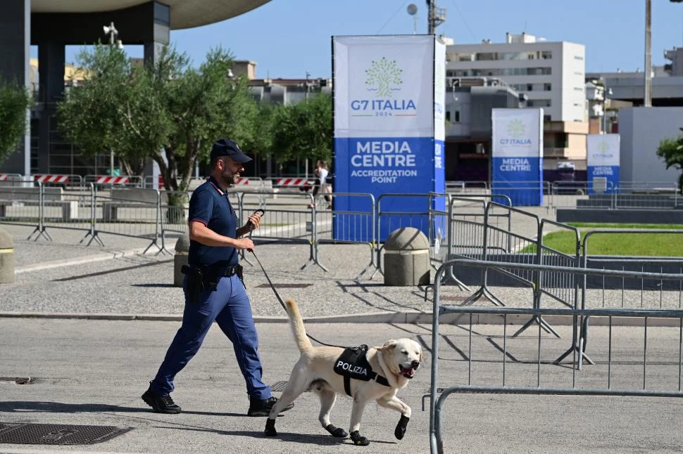 CONTROLES. Policías con perros recorren el centro de prensa en Bari, a 60 kilómetros del lugar del encuentro. 