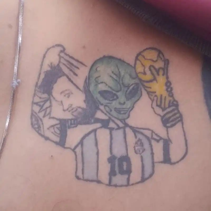 De otro planeta. Lionel Messi sacándose su cara, devenida en máscara, y abajo se descubre un alienígena. 