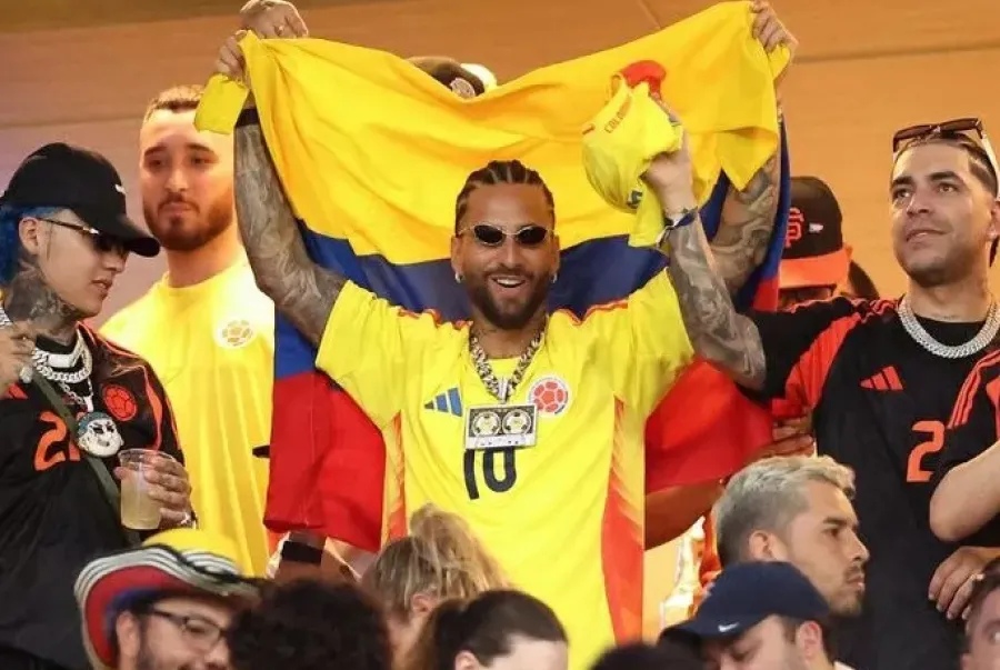 DE LA ALGARABÍA A LA BRONCA. Maluma celebra con la bandera de Colombia antes de la derrota de su equipo. / AFP