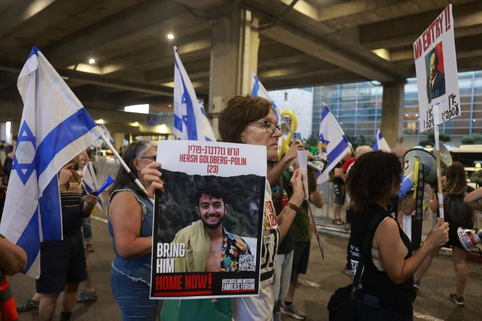 PRESIONES. Familiares de los cautivos en manos de Hamas protestan en el aeropuerto Ben Gurion, desde donde partía el primer ministro Netanyahu. 