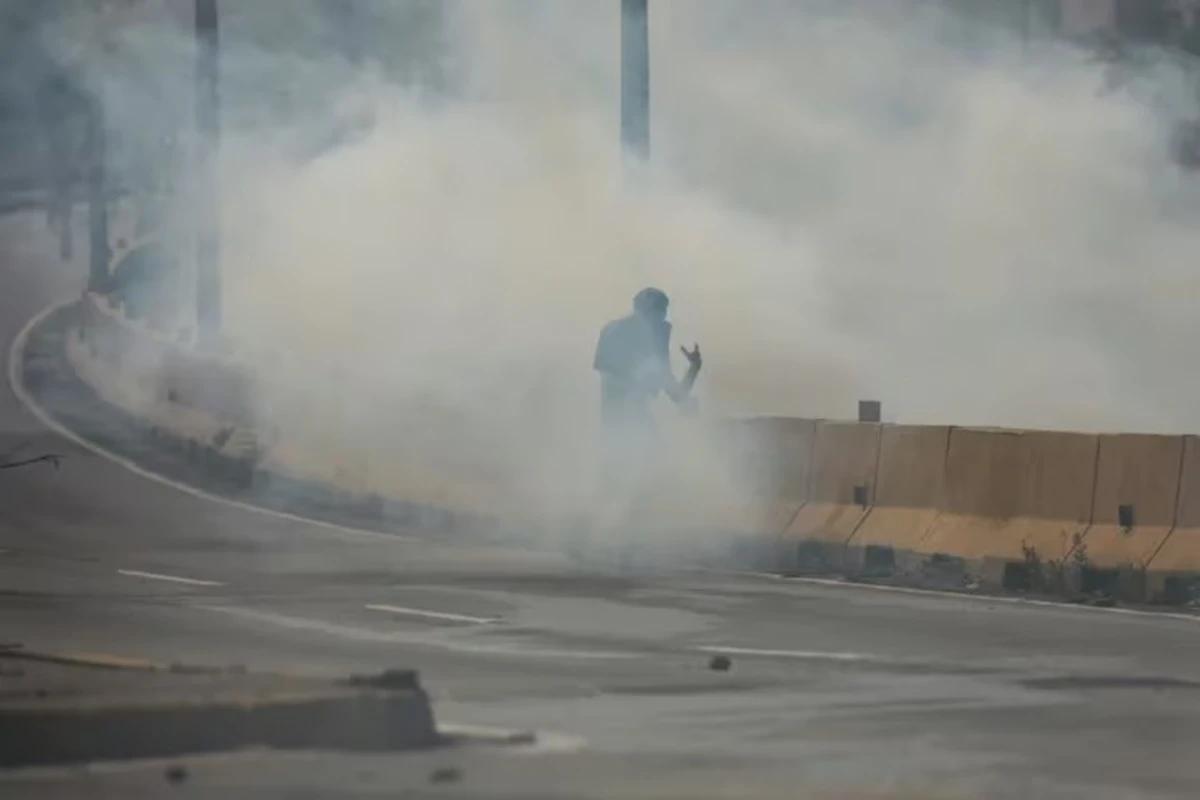VENEZUELA. Un manifestante camina en medio de gases lacrimógenos durante los enfrentamientos con las fuerzas de seguridad en Caracas.