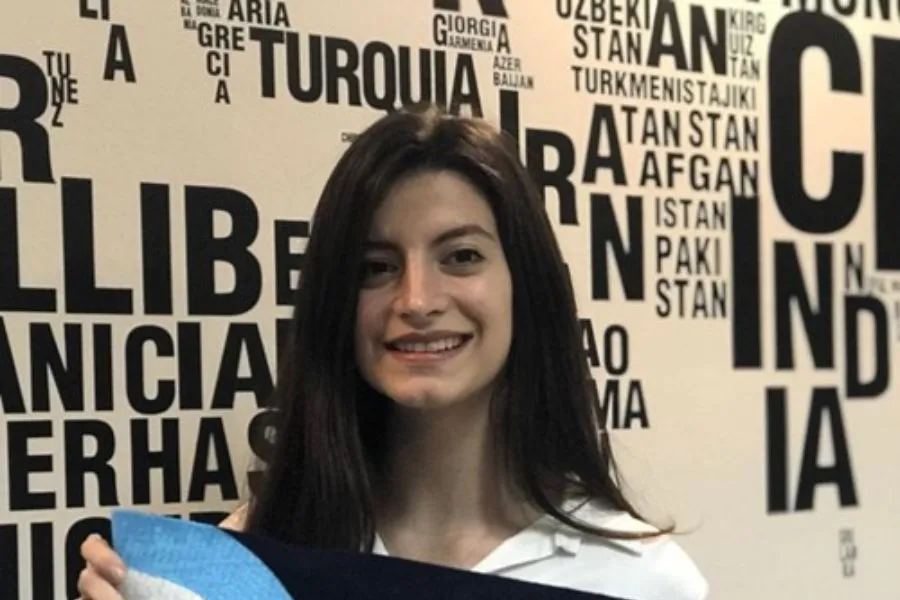 BECARIA ARGENTINA. Luciana Paione Oleszuk posando junto a la bandera de su universidad./UADE