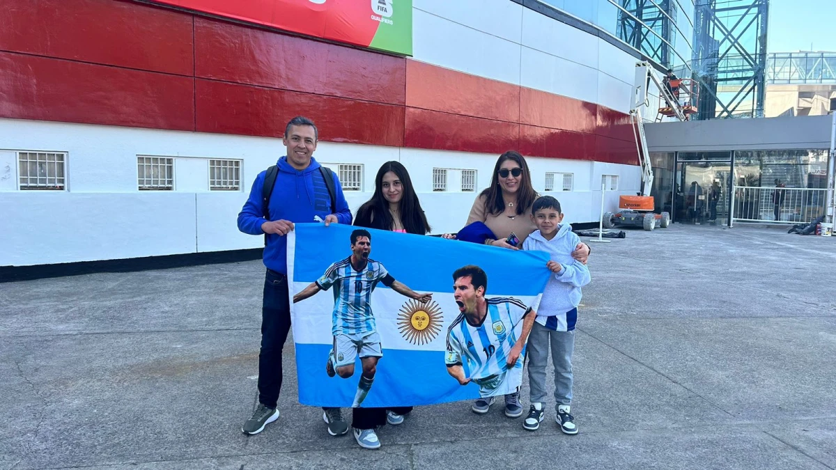 LISTOS PARA DESPEDIR A FIDEO. En las boleterías del estadio de River José, Josefina, Laura y Joaquín lucen una bandera en la que aparece Lionel Messi.