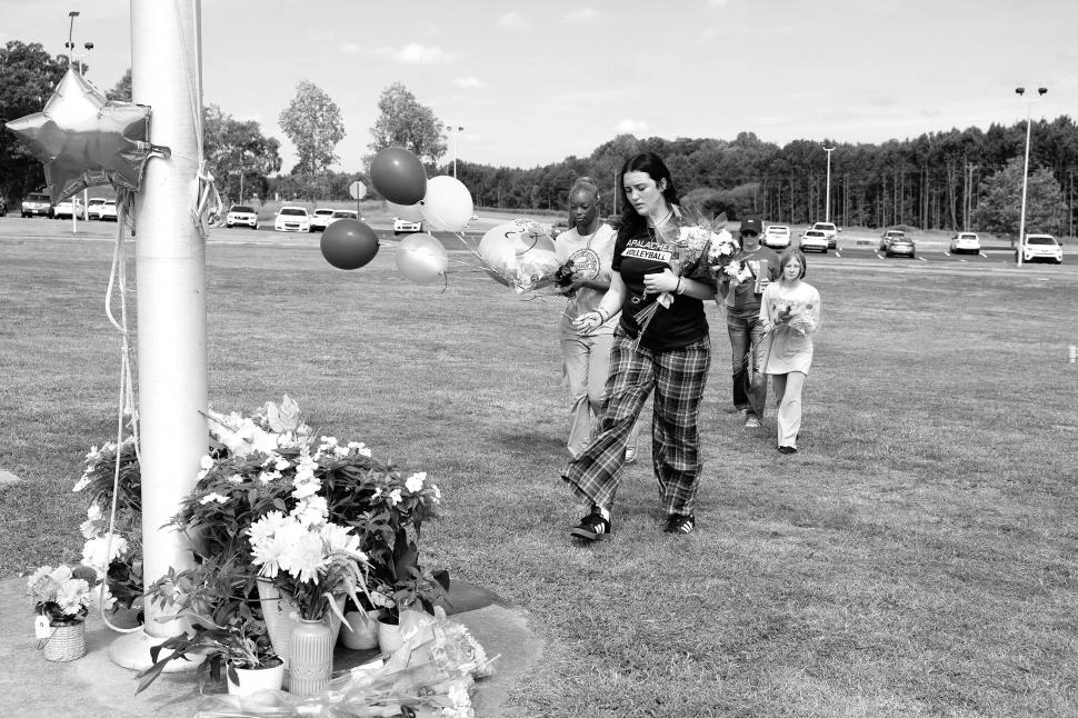 ESCENA REPETIDA. Estudiantes dejan flores y globos en memoria de sus muertos, en la escuela Apalachee.