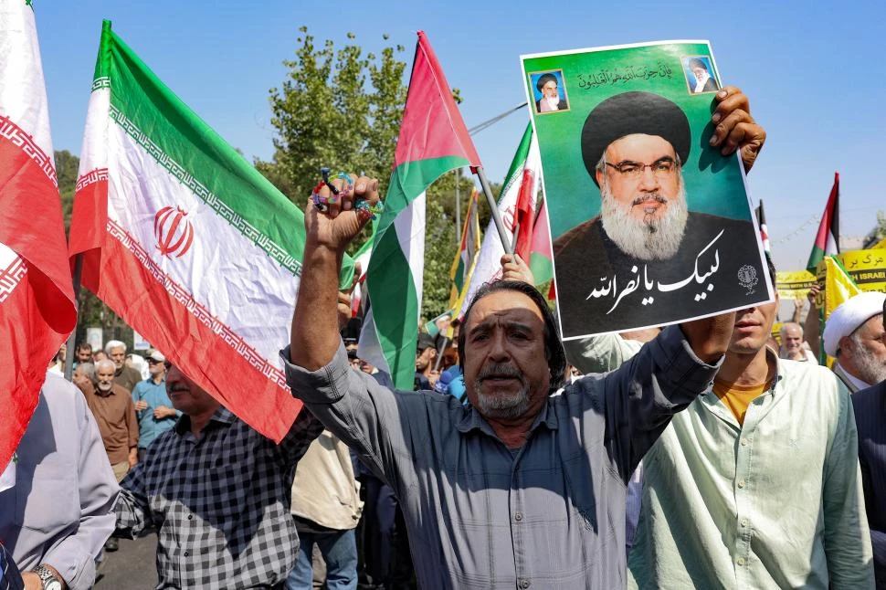 PROTESTAS. Con la imagen de Nasrallah y banderas palestinas, cientos de personas llenaron las calles de Teherán, en una marcha contra Israel.