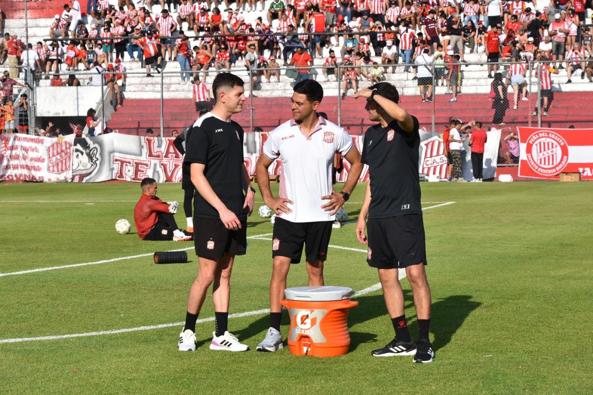 EN LA CANCHA. Julián Jerez Amdoni habla con integrantes del cuerpo técnico, en la previa de un partido.