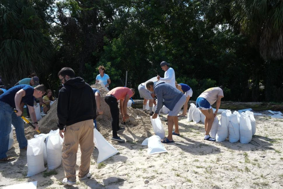 TAMPA. Los residentes preparan defensas con bolsas de arena.