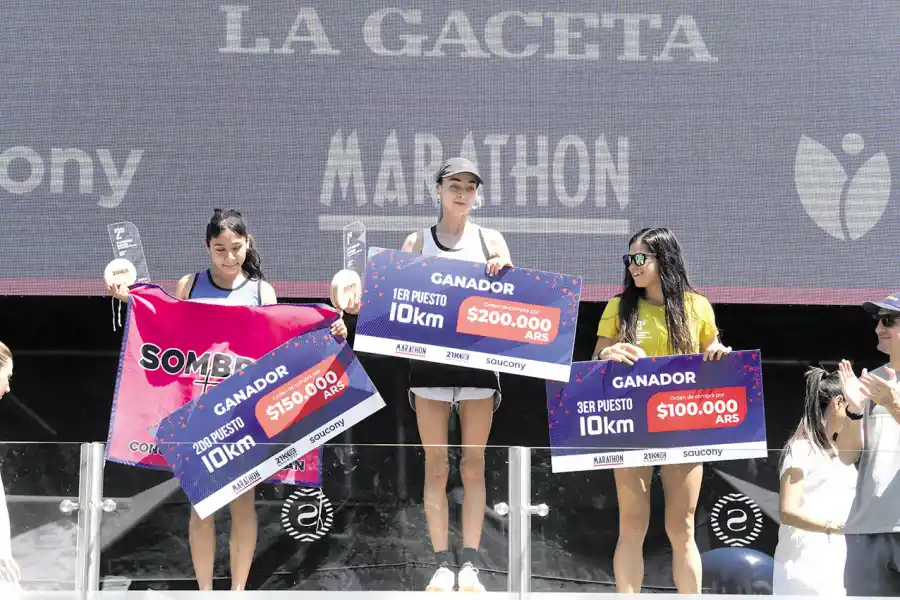 EN LO MÁS ALTO. Landers (centro) exhibe su premio por imponerse en los 10K.