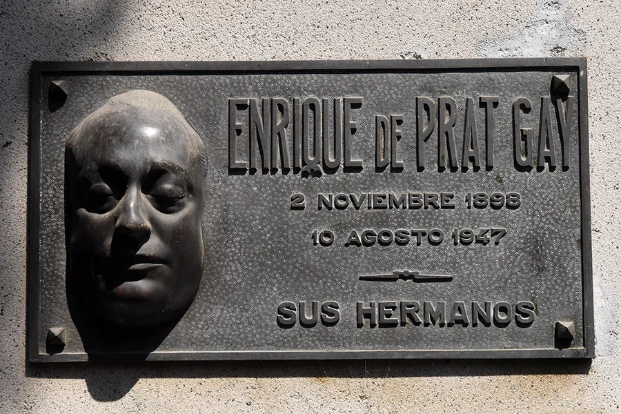 ENRIQUE DE PRAT GAY. El rostro del escultor asoma en la placa con la forma de una máscara mortuoria. Una de las más impresionantes.
