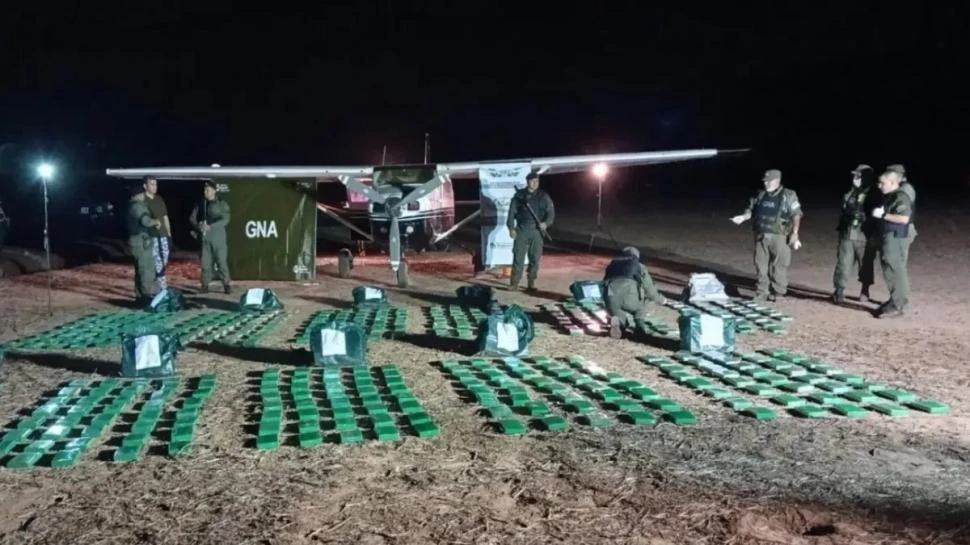 EL BALANCE FINAL. Gendarmes acomodan en el suelo los panes de cocaína que estaban dentro de la avioneta que aterrizó en una zona rural.