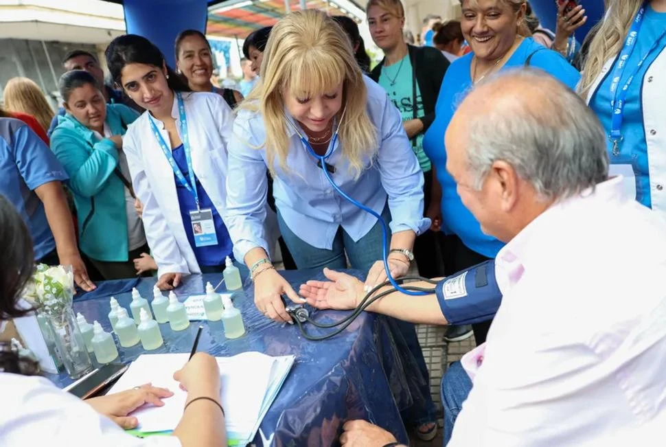 EN EL MICROCENTRO. La intendenta Chahla controla la presión arterial a un vecino en la estación climática que el municipio instaló en la peatonal. comunicación S.m.t.