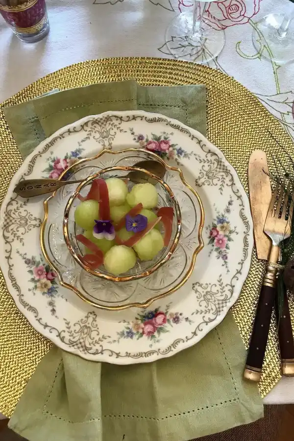 Melón con rulos de jamón crudo y flores comestibles.