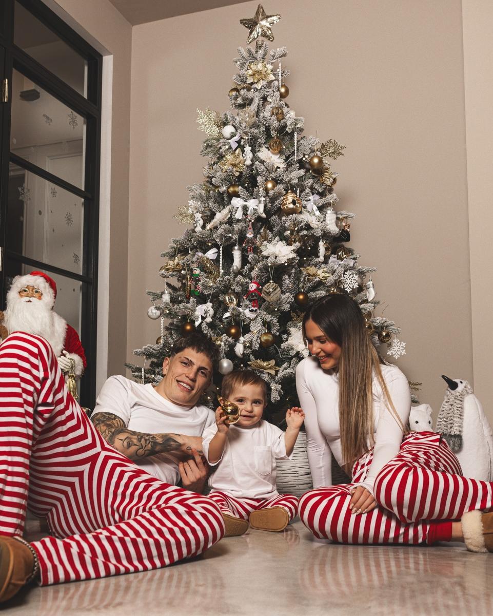 LISTOS PARA LA OCASIÓN. Alejandro Garnacho posa junto a su familia y el árbol de Navidad.