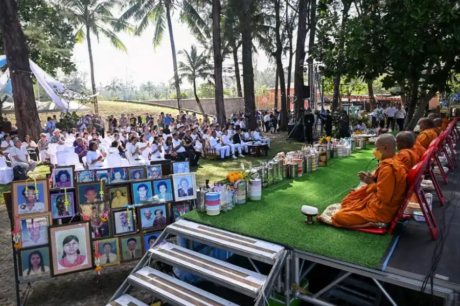 CONFLUENCIA RELIGIOSA. Monjes y fieles de distintas creencias durante el homenaje junto a retratos de víctimas en el sitio de memoria en Thailandia.