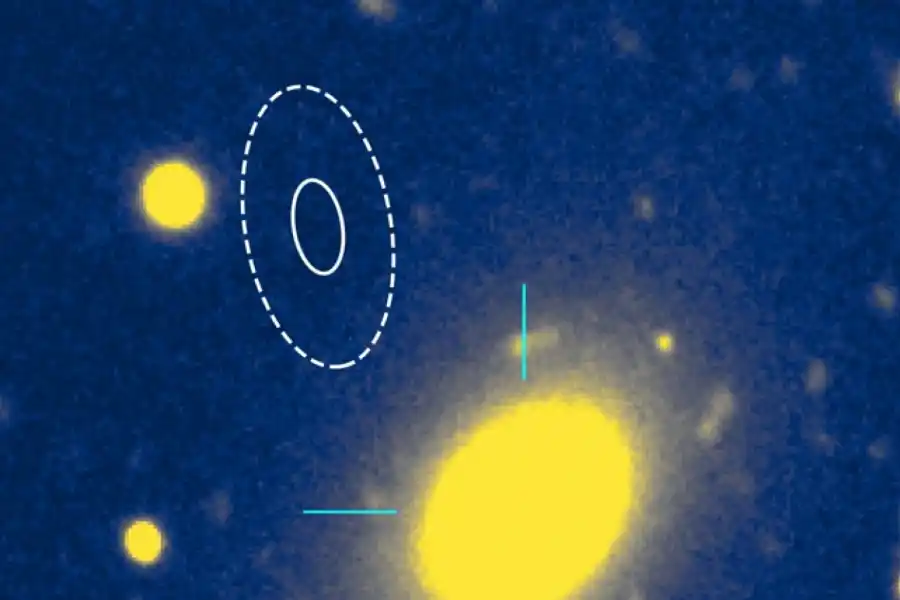 La ubicación de la ráfaga rápida de radio , indicada por los contornos ovalados, está en las afueras de una galaxia elíptica masiva, el óvalo amarillo a la derecha. ( Observatorio Gemini )