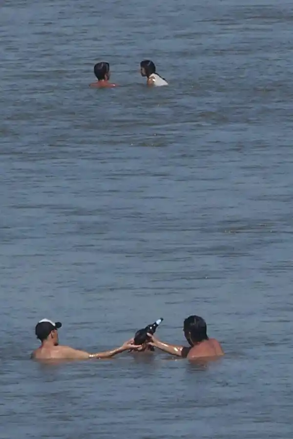 COMO EN UN BAR. Dos amigos comparten una cerveza, mientras se refrescan en el río. la gaceta / fotos de osvaldo ripoll y franco vera