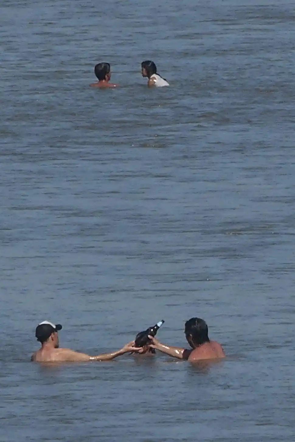 COMO EN UN BAR. Dos amigos comparten una cerveza, mientras se refrescan en el río. la gaceta / fotos de osvaldo ripoll y franco vera