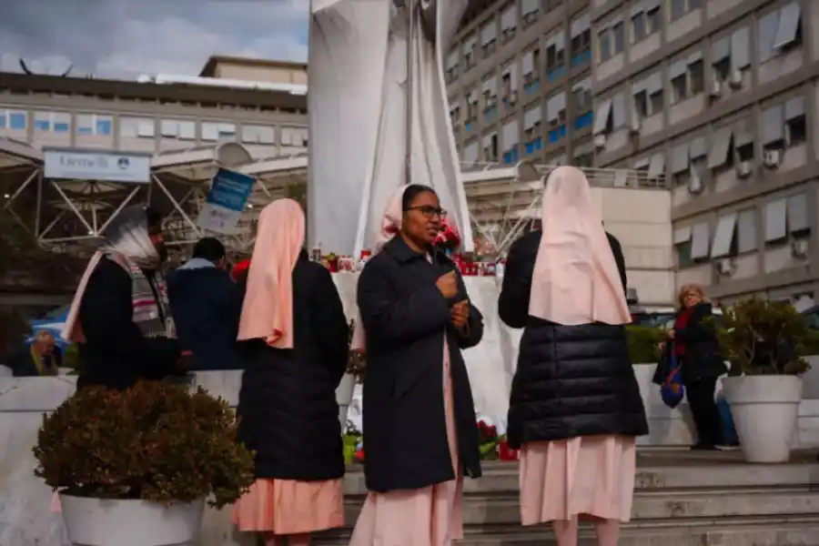 CIUDAD DEL VATICANO. Unas monjas rezan por el papa Francisco ante la estatua del pontífice Juan Pablo II en el exterior del hospital Gemelli de Roma afp