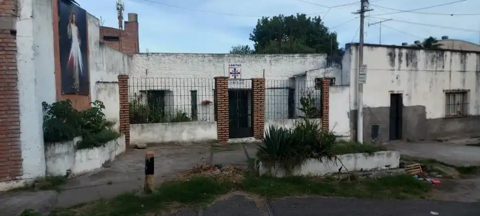 DESTINO: LA FE. En Pasaje García, las vías terminan en la capilla De la Divina Misericordia, con cartel de Cáritas.