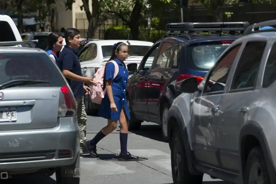 EN RIESGO. Una familia cruza por la senda peatonal en medio del tránsito congestionado.