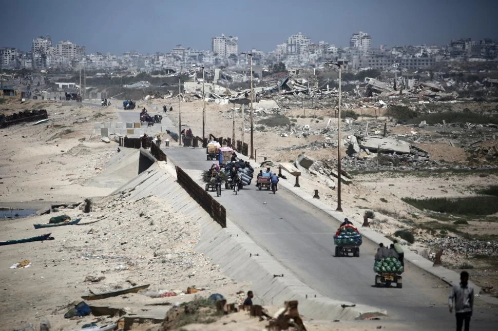 ÉXODO. Cientos de palestinos se desplazan por la ruta costera de Al-Rashid, ante la orden de evacuación israelí.  