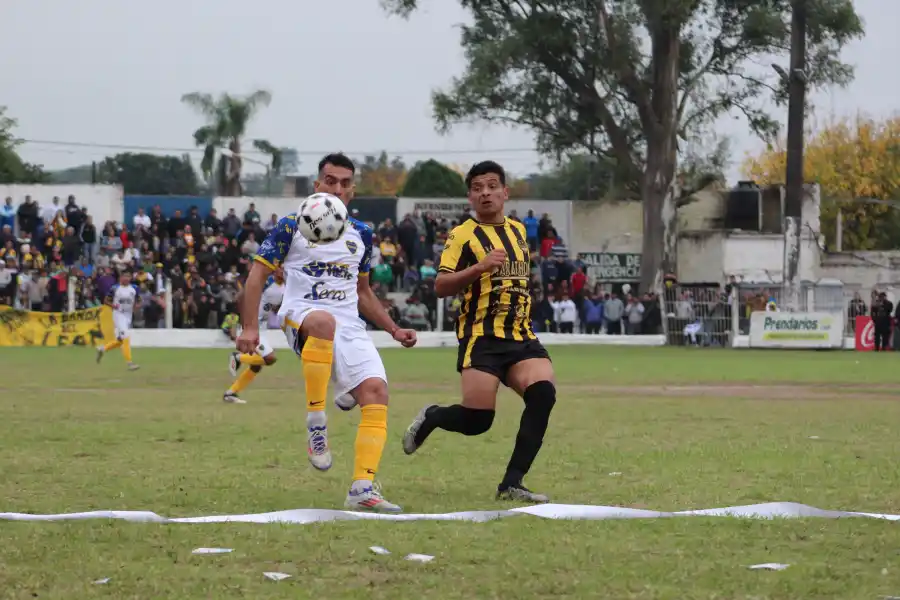 Gastón Olmos, delantero de Villa Mitre, disputa la pelota con Víctor Carrizo, de Talleres.